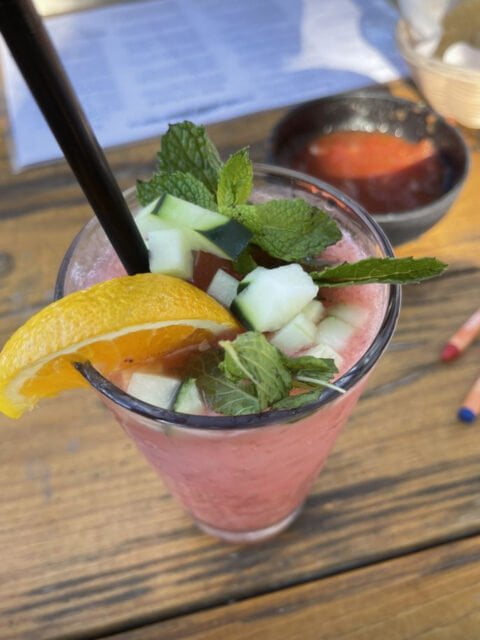 Cisco's Mexican Restaurant: A refreshing watermelon drink featuring a delightful slice of orange and cucumber, perfect for happy hour or catering events with a Mexican food theme.