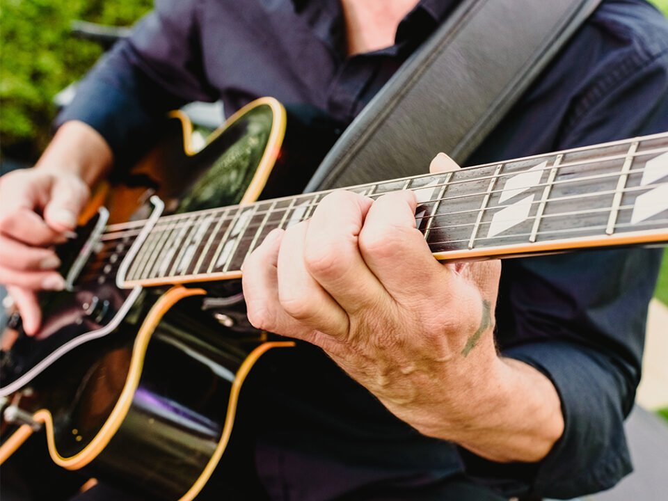 Cisco's Mexican Restaurant: A man playing an electric guitar outdoors during Happy Hour.